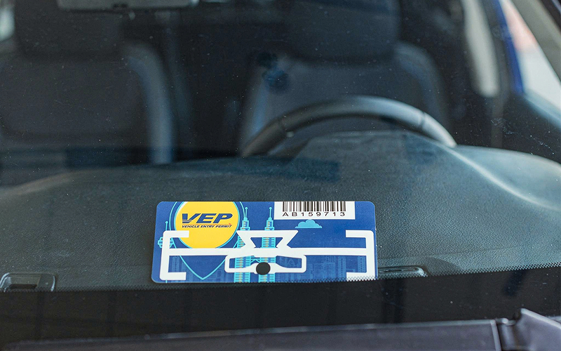 Malaysia Vehicle Entry Permit tag displayed on a car windshield.